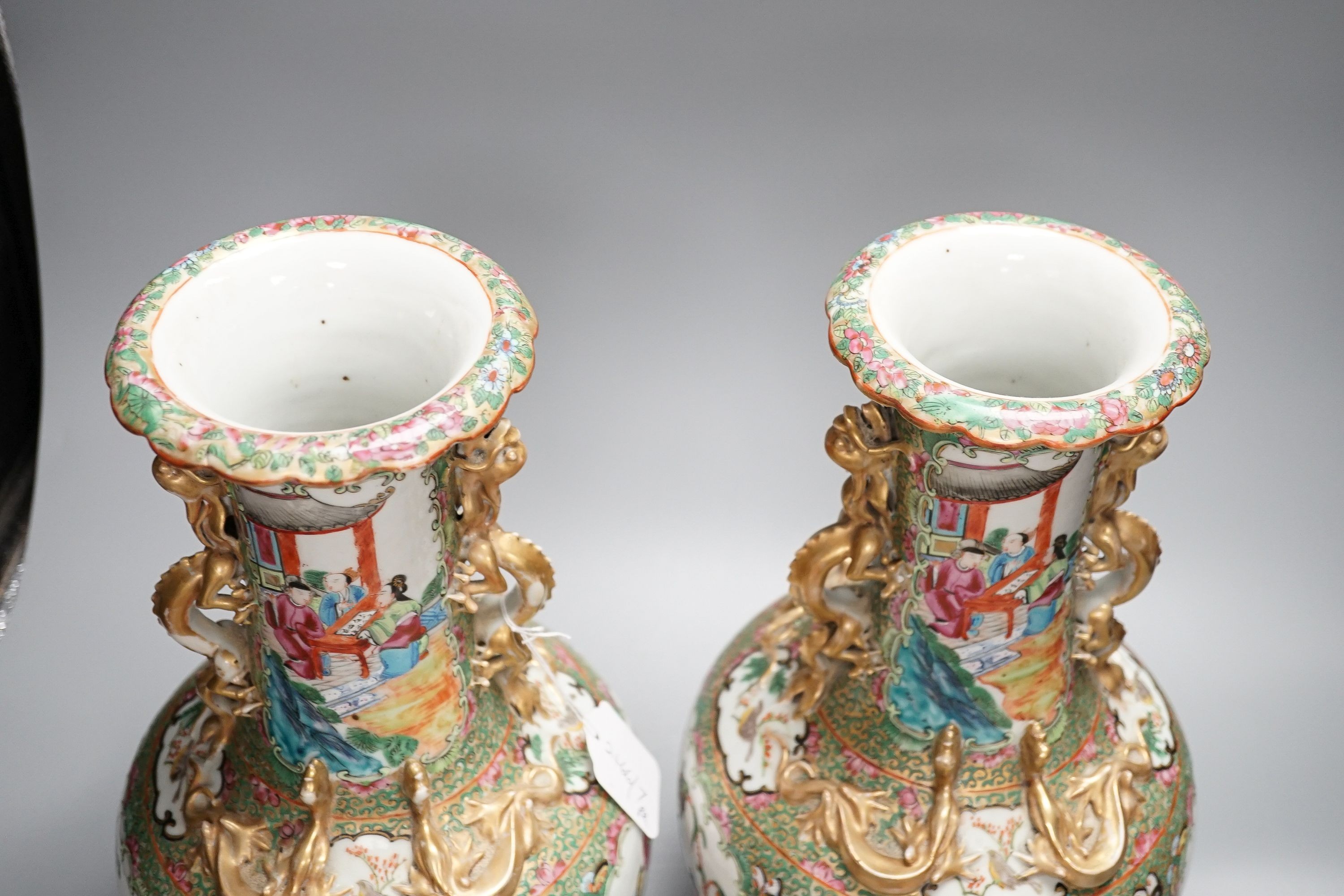 A pair of late 19th century Chinese famille rose vases, decorated with figures, birds and butterflies, twin lion dog handles, height 35cm